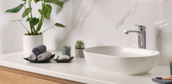 Modernes Waschbecken mit Armatur und Deko im Bad