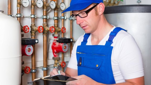 Installateur prüft Heizungsanlage bei einer Heizungssanierung im Altbau