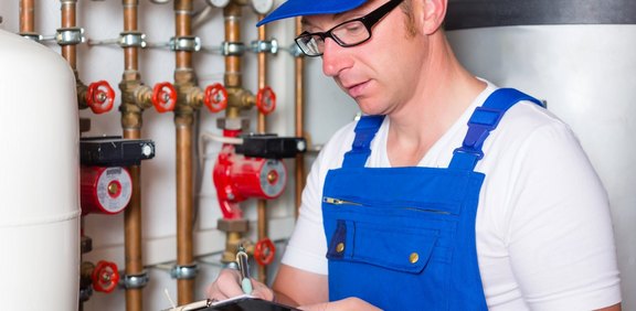 Installateur prüft Heizungsanlage bei einer Heizungssanierung im Altbau