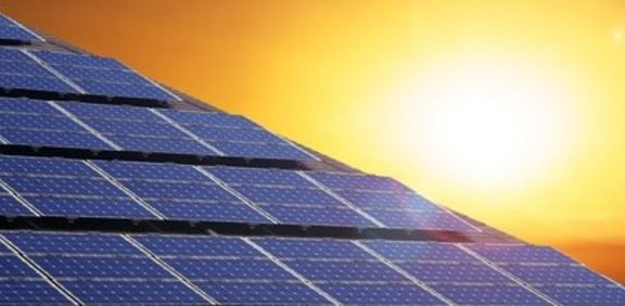 Hände formen ein Haus vor Wiese und blauem Himmel