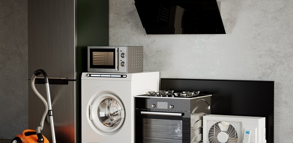 Verschiedene Haushaltsgeräte wie Kühlschrank, Waschmaschine und Herd nebeneinander